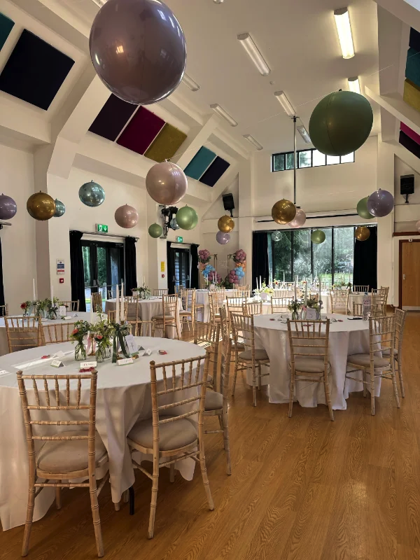 Wedding tables in hall with whicker chairs